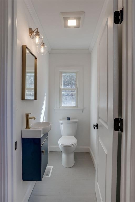 bathroom with baseboards, ornamental molding, and toilet