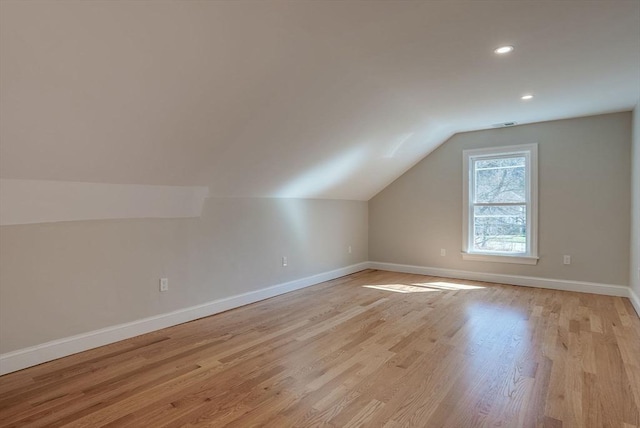 additional living space featuring light wood-style floors, baseboards, lofted ceiling, and recessed lighting
