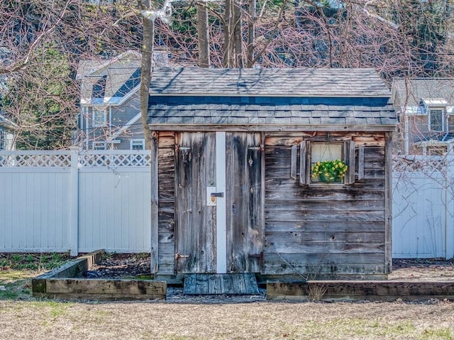 view of outbuilding with fence and an outbuilding