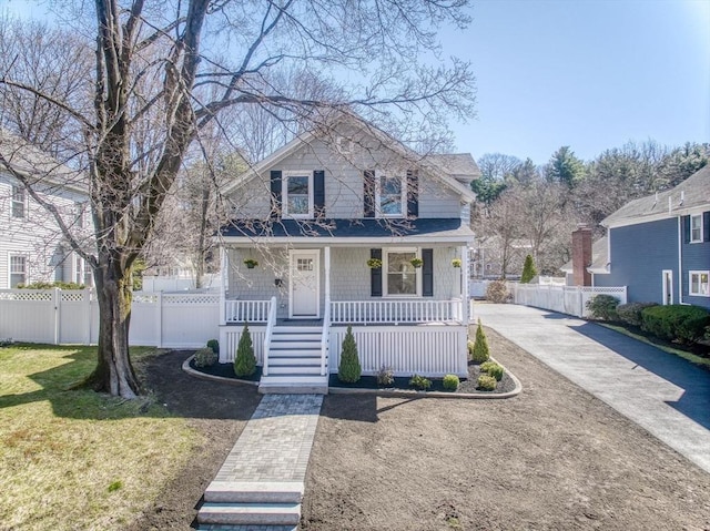view of front facade featuring a front yard, a porch, and fence