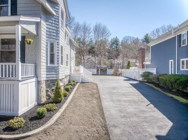 view of side of home featuring fence and driveway
