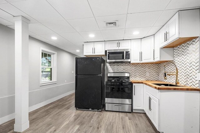 186 Chapel St, Abington, MA 02351 - kitchen with gas range, stainless steel microwave, freestanding refrigerator, butcher block counters, and light wood-style flooring