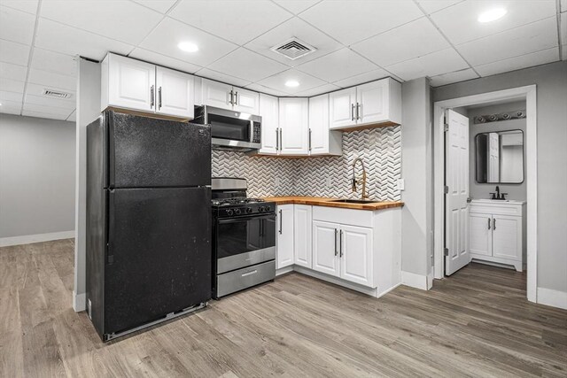 186 Chapel St, Abington, MA 02351 - kitchen with appliances with stainless steel finishes, wood counters, baseboards, a drop ceiling, and white cabinets