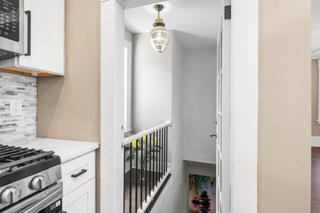 186 Chapel St, Abington, MA 02351 - kitchen with tasteful backsplash, white cabinetry, stainless steel microwave, pendant lighting, and light stone counters