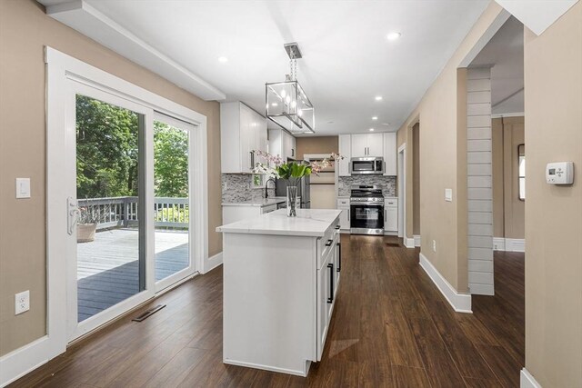 186 Chapel St, Abington, MA 02351 - kitchen featuring stainless steel appliances, white cabinetry, tasteful backsplash, dark wood-style floors, and baseboards