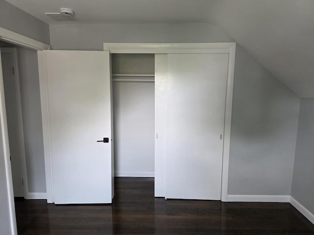 32 Central Ave, Everett, MA 02149 - unfurnished bedroom featuring lofted ceiling, dark wood-style flooring, baseboards, and a closet