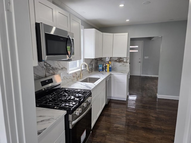 32 Central Ave, Everett, MA 02149 - kitchen with stainless steel appliances, a sink, dark wood finished floors, light stone countertops, and decorative backsplash