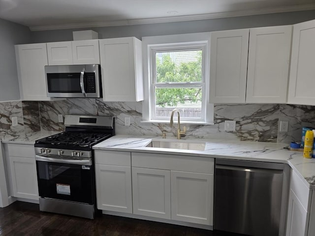 32 Central Ave, Everett, MA 02149 - kitchen with stainless steel appliances, a sink, crown molding, and white cabinetry