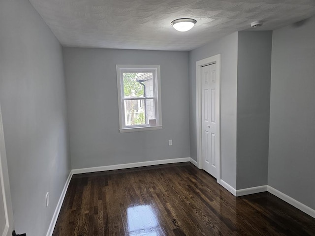 32 Central Ave, Everett, MA 02149 - spare room with dark wood finished floors, baseboards, and a textured ceiling