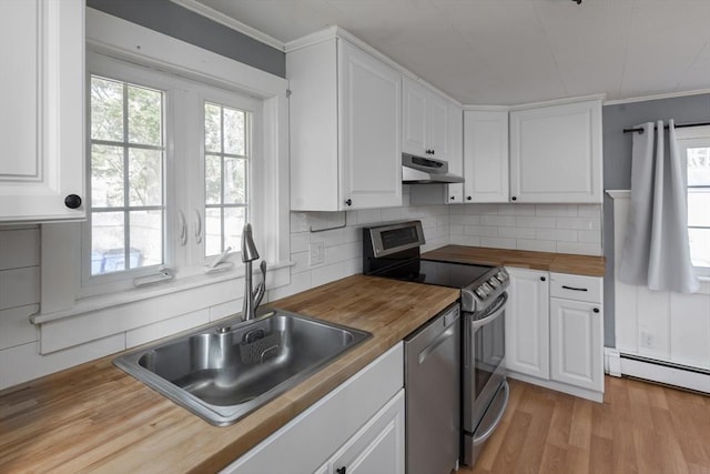 kitchen featuring appliances with stainless steel finishes, under cabinet range hood, white cabinetry, and wood counters