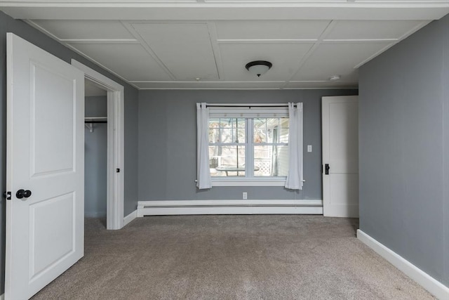 unfurnished bedroom with a closet, baseboards, carpet flooring, and baseboard heating