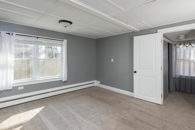 empty room with baseboards, baseboard heating, and light colored carpet