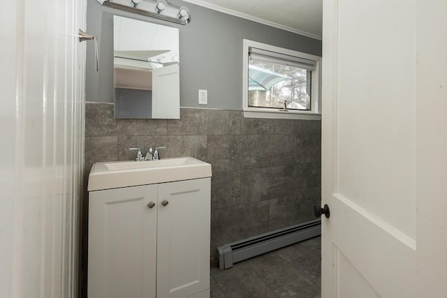 bathroom featuring vanity, tile walls, ornamental molding, baseboard heating, and wainscoting