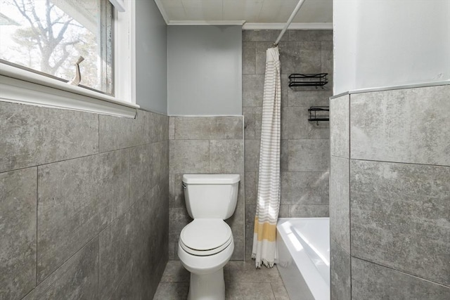 bathroom with shower / bath combo, tile patterned flooring, toilet, and tile walls