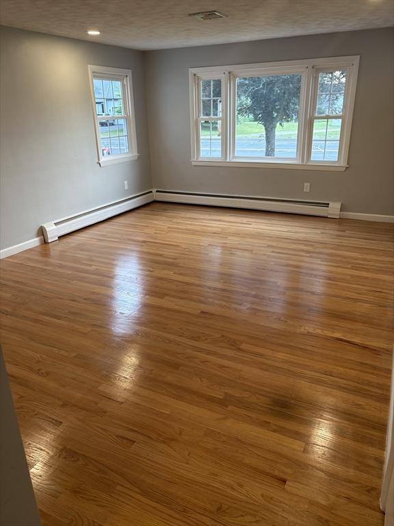 945 Shoemaker Ln, Agawam, MA 01030 - spare room with wood finished floors and a baseboard radiator