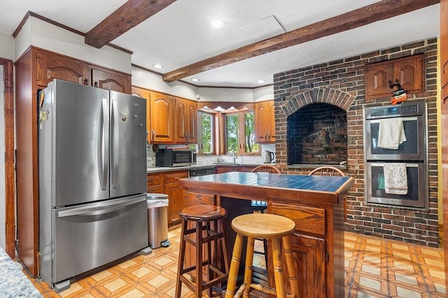 14 Franklin Ter, Boston, MA 02136 - kitchen with appliances with stainless steel finishes, beamed ceiling, tile countertops, a breakfast bar area, and brown cabinetry