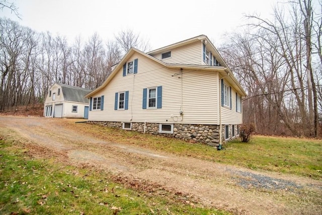 view of side of property with a lawn and an outbuilding