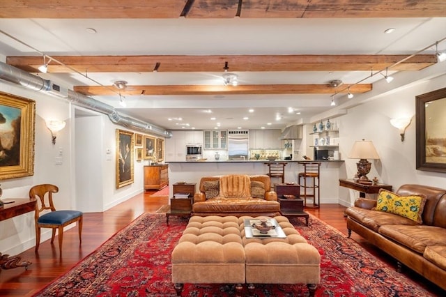 living room featuring baseboards, beam ceiling, and wood finished floors