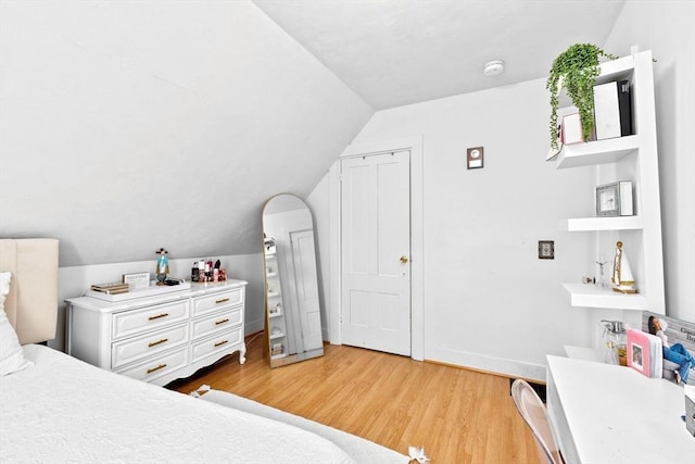 bedroom with light wood-style flooring and vaulted ceiling