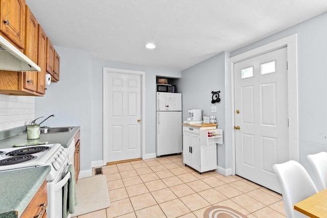 kitchen with light tile patterned floors, white appliances, visible vents, backsplash, and light countertops