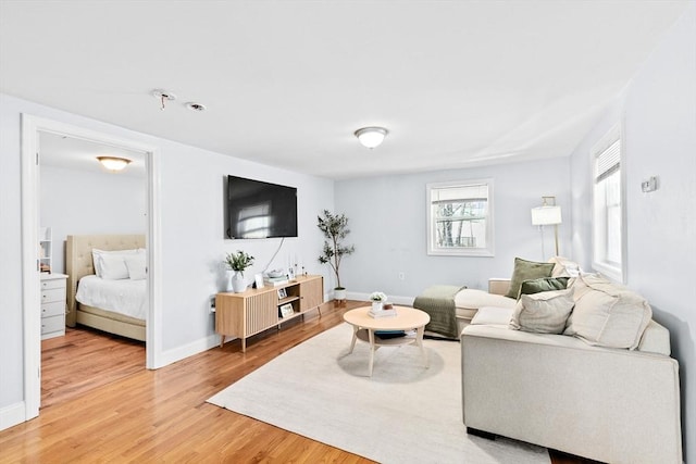 living area featuring baseboards and light wood-style floors