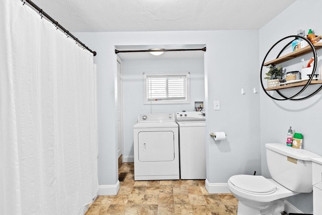 full bathroom featuring separate washer and dryer, stone finish flooring, toilet, vanity, and baseboards