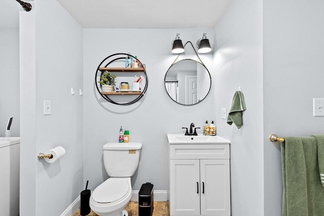 bathroom featuring baseboards, washer / clothes dryer, toilet, and vanity