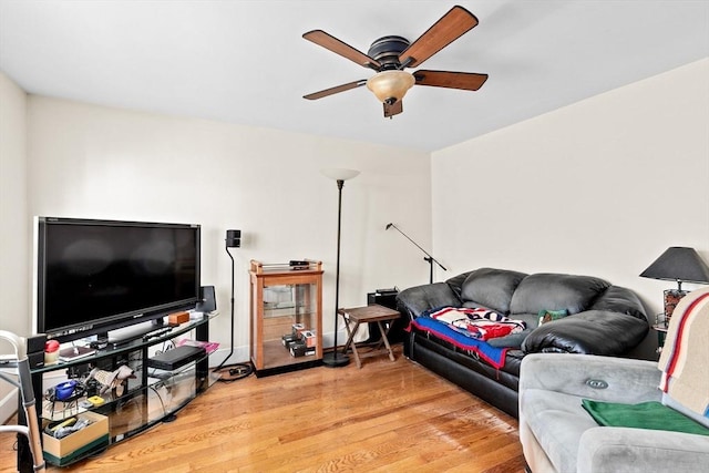 living room with a ceiling fan and light wood-style flooring