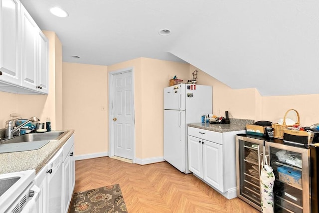 kitchen with white cabinets, recessed lighting, a sink, and freestanding refrigerator