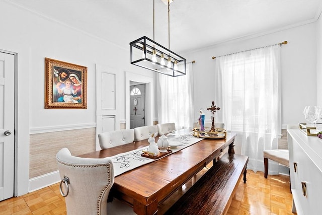 dining room featuring ornamental molding, a notable chandelier, and baseboards