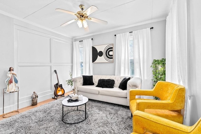living area featuring crown molding, ceiling fan, and a wealth of natural light