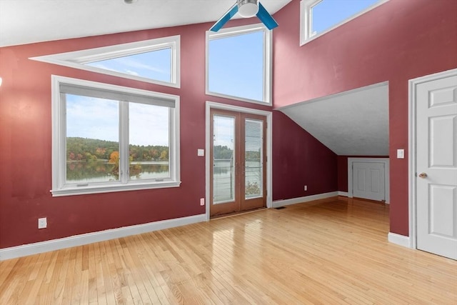 additional living space featuring ceiling fan, light hardwood / wood-style flooring, a water view, and lofted ceiling