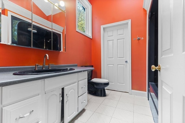 bathroom with tile patterned flooring, vanity, and toilet