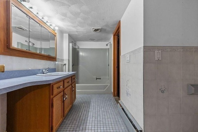 bathroom featuring vanity, tile patterned flooring, a textured ceiling, tile walls, and shower / bath combination