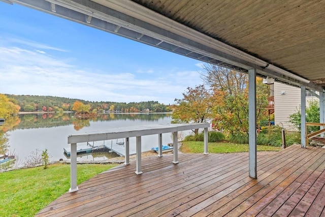 wooden terrace featuring a lawn and a water view