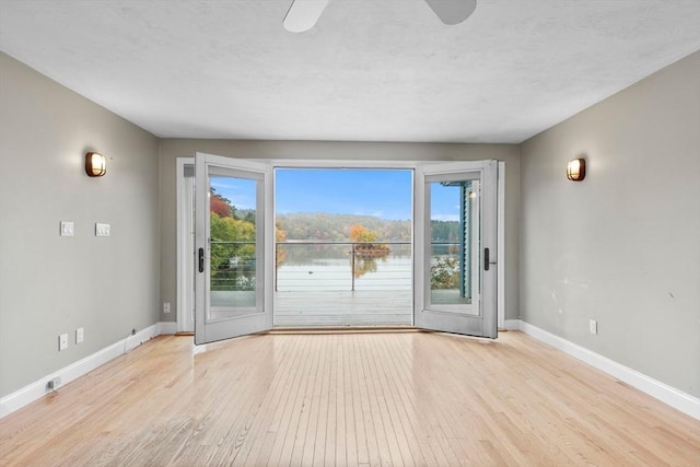 entryway with ceiling fan, a wealth of natural light, and light hardwood / wood-style flooring