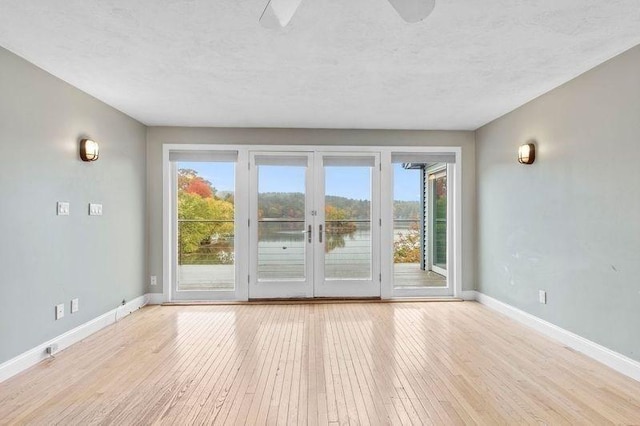 spare room featuring light hardwood / wood-style floors and a textured ceiling