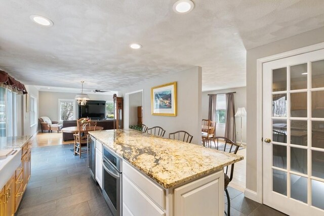 2 Spencer Way, Merrimac, MA 01860 - kitchen featuring light stone countertops, a kitchen bar, recessed lighting, open floor plan, and a center island