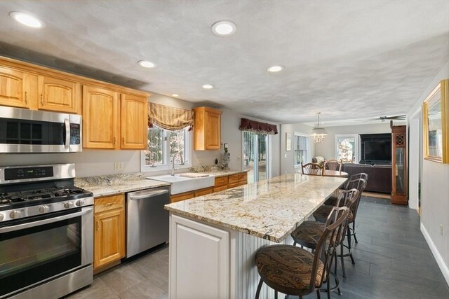 2 Spencer Way, Merrimac, MA 01860 - kitchen featuring a breakfast bar, a kitchen island, appliances with stainless steel finishes, a sink, and open floor plan