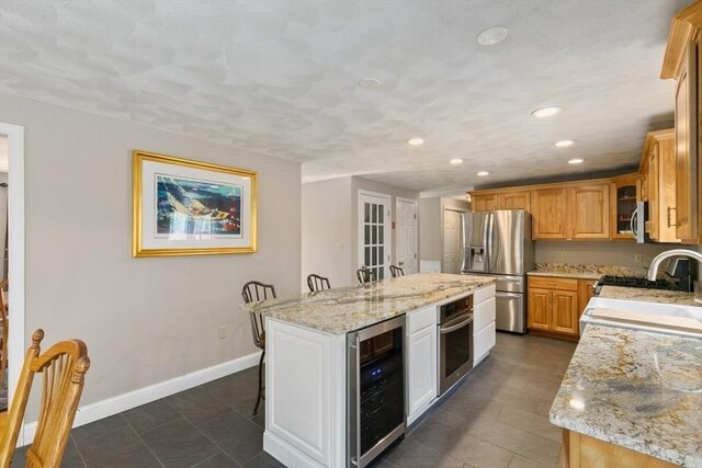 2 Spencer Way, Merrimac, MA 01860 - kitchen featuring baseboards, a kitchen island, appliances with stainless steel finishes, beverage cooler, and light stone counters
