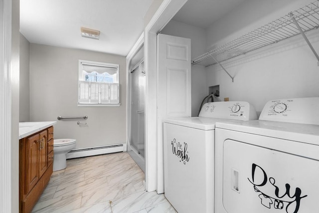 washroom featuring a baseboard heating unit, marble finish floor, laundry area, and washing machine and dryer