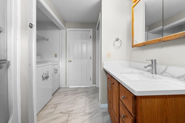 bathroom with washing machine and dryer, vanity, baseboards, and marble finish floor
