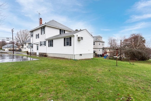 back of house with a wall mounted air conditioner, a yard, and a chimney