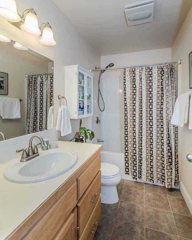 full bathroom with tile patterned floors, toilet, vanity, and shower / bath combination with curtain