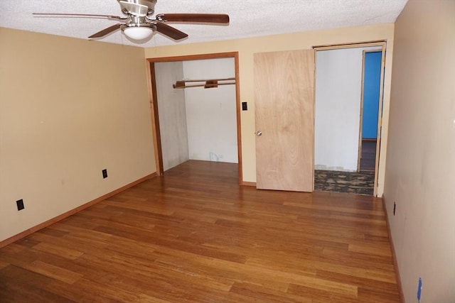 empty room featuring baseboards, a textured ceiling, wood finished floors, and a ceiling fan