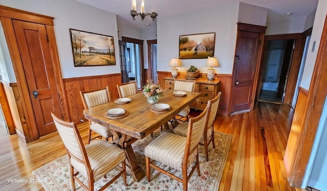 dining space with light wood-type flooring and a chandelier