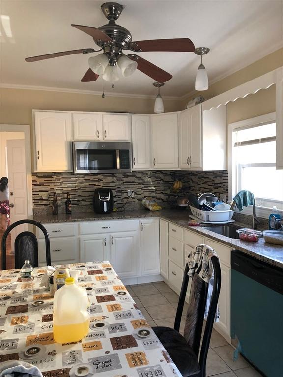 kitchen with ornamental molding, a ceiling fan, stainless steel microwave, white cabinetry, and dishwashing machine