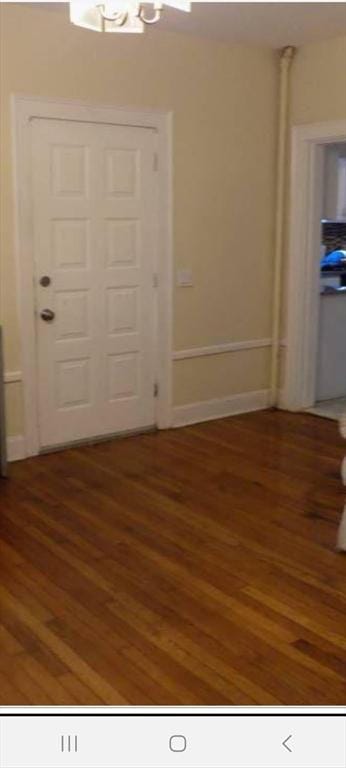 foyer entrance with baseboards and wood finished floors