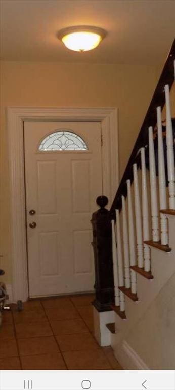 entrance foyer featuring light tile patterned floors and stairway