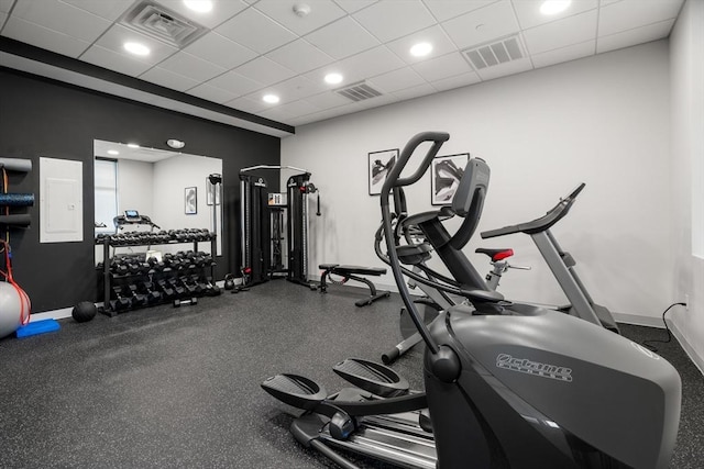 gym with visible vents, a paneled ceiling, and baseboards